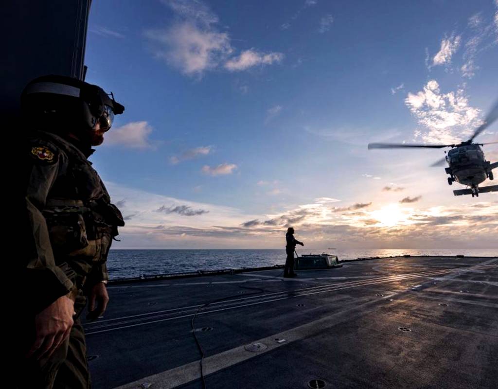 Lieutenant Commander Matthew Schroder, left, observes the departure of a U.S. Navy MH-60R from HMAS Ballarat’s flight deck during Exercise Malabar. Leading Seaman Shane Cameron Photo