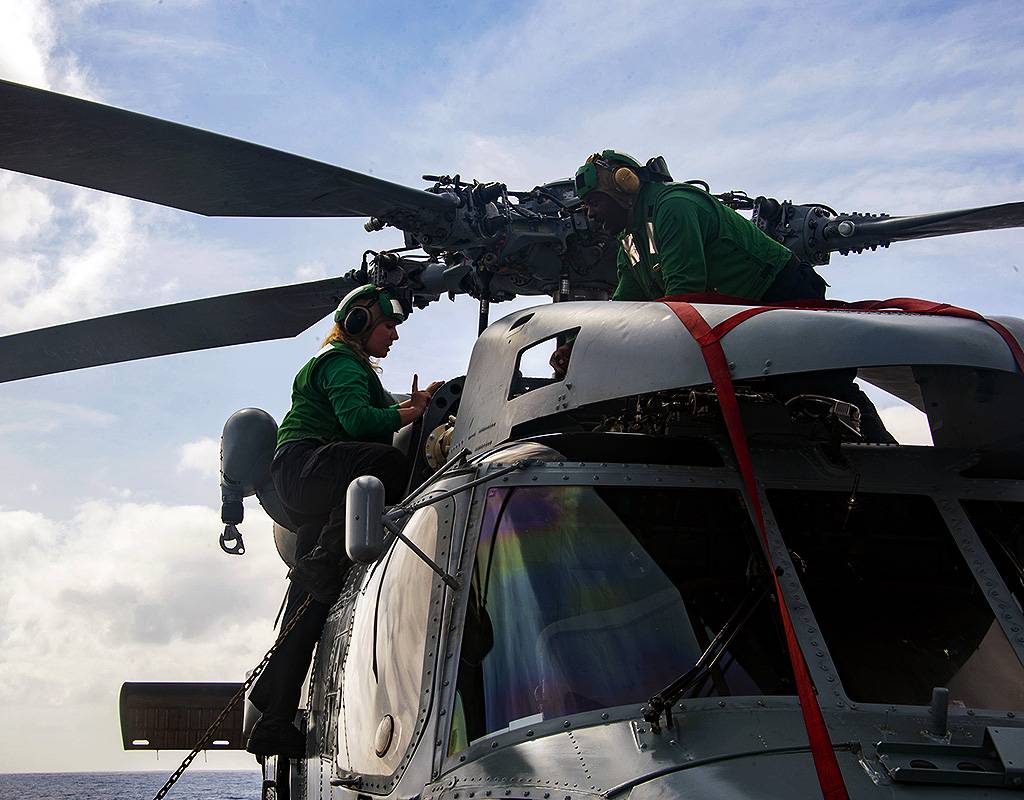 Aviation Structural Mechanic 3rd Class Sierra Roper, from Grand Prairie, Texas, left, and Aviation Structural Mechanic 2nd Class Travis Sims, from Brooklyn, Illinois, conduct pre-flight maintenance on an MH-60R Sea Hawk, attached to the Swamp Foxes, of Helicopter Maritime Strike Squadron (HSM) 74, aboard the Arleigh Burke-class guided-missile destroyer USS James E. Williams (DDG 95). U.S. Navy Photo by Mass Communication Specialist 3rd Class Jairus P. Bailey