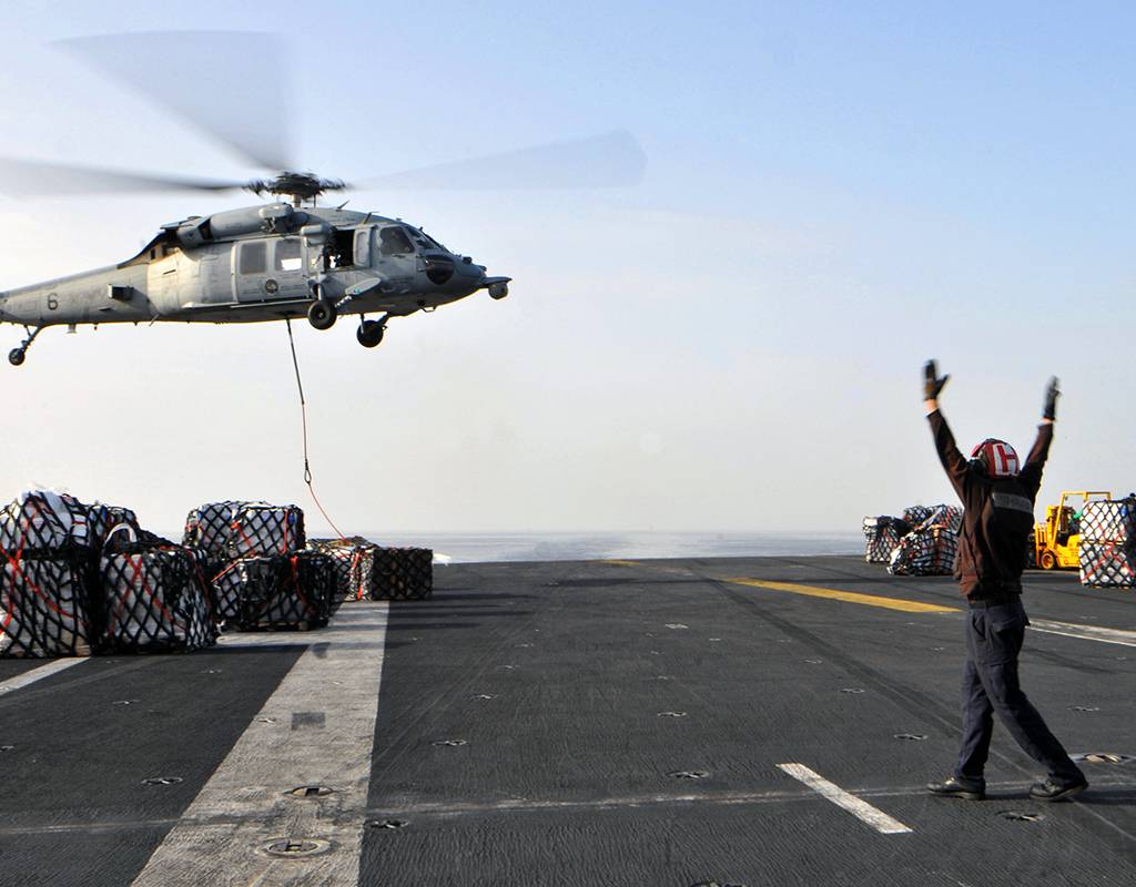 An MH-60S Seahawk helicopter assigned to Helicopter Sea Combat Squadron 12 on the flight deck of the USS Abraham Lincoln during a replenishment at sea. U.S. Navy Photo by Mass Communication Specialist 3rd Class Christina I. Naranjo