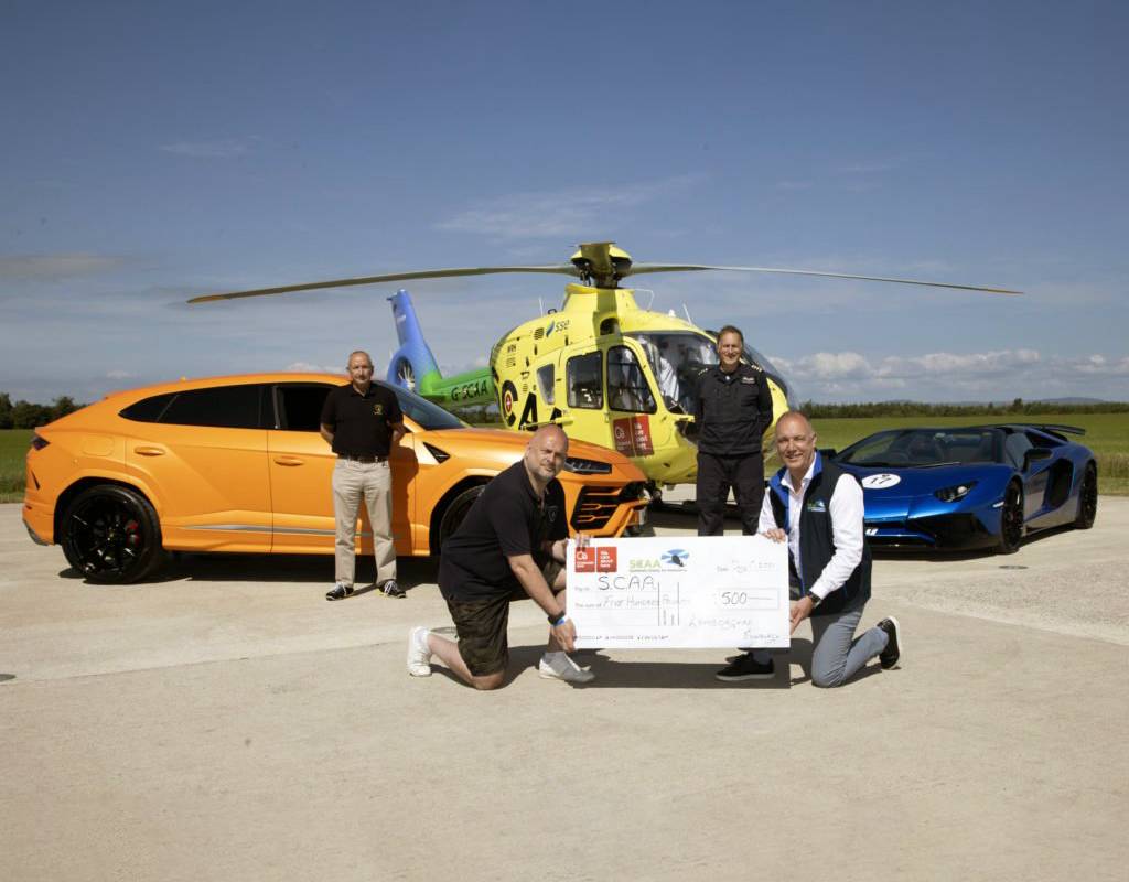 Andy Canning, general manager of Lamborghini Edinburgh, presents a check for £500 to Nick Harvey, director of fundraising and communications at SCAA. Also pictured is event coordinator Mark Ryan of Driving Scotland and Helimed 76 pilot Captain Adam Fergusson. Graeme Hart Photo