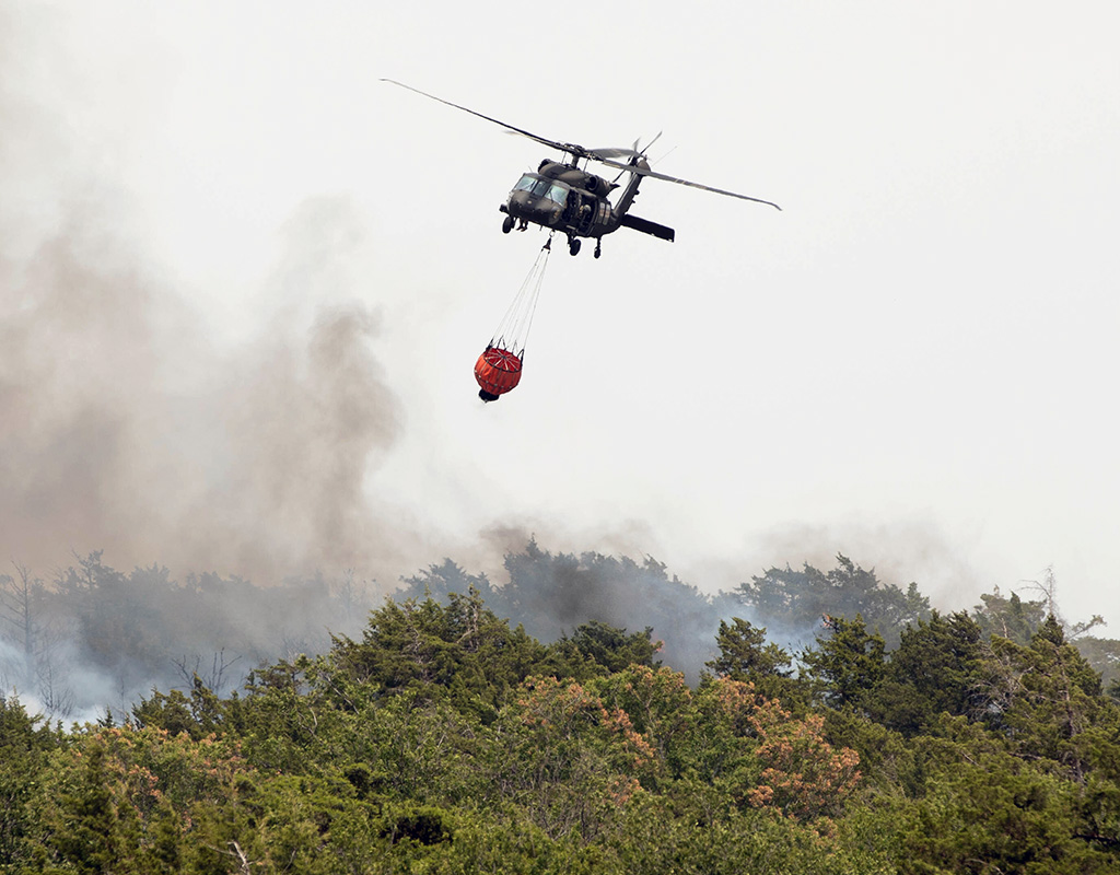 An Oklahoma National Guard UH-60 Black Hawk prepares to refill the attached Bambi Bucket in order to continue fighting a wildfire in Blaine County, Oklahoma. Spc. Caleb Stone for 145th Mobile Public Affairs Detachment Photo