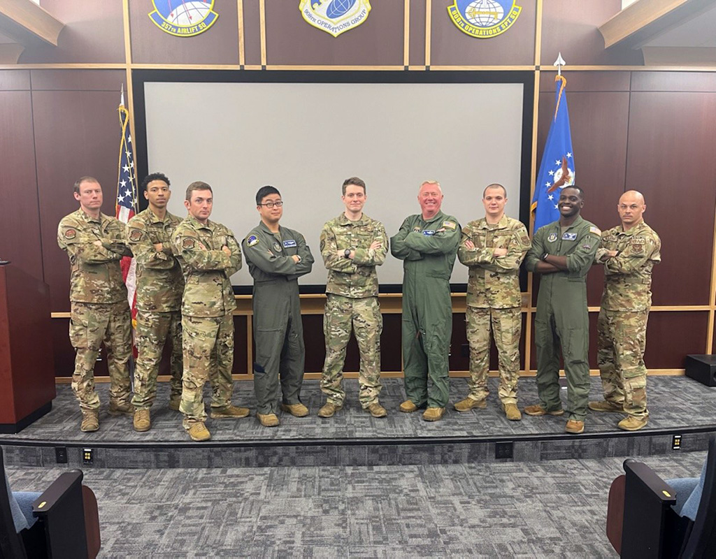Eight 908th Airlift Wing loadmasters and flight engineers flank Basic Special Missions Aviator Course instructor, Staff Sgt. Raymond Bourne, center, for a graduation photo April 27, 2022 at Maxwell Air Force Base, Alabama. Bradly J. Clark for U.S. Air Force Photo