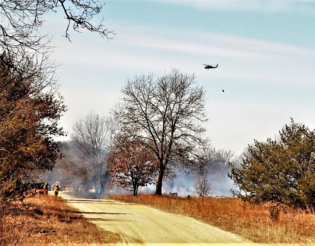 A UH-60 Black Hawk helicopter belonging to the 1st Battalion, 147th Aviation Regiment of Madison, Wis., carries a giant water bucket to a douse a fire March 28, 2022. Scott T. Sturkol for Fort McCoy Public Affairs Office Photo
