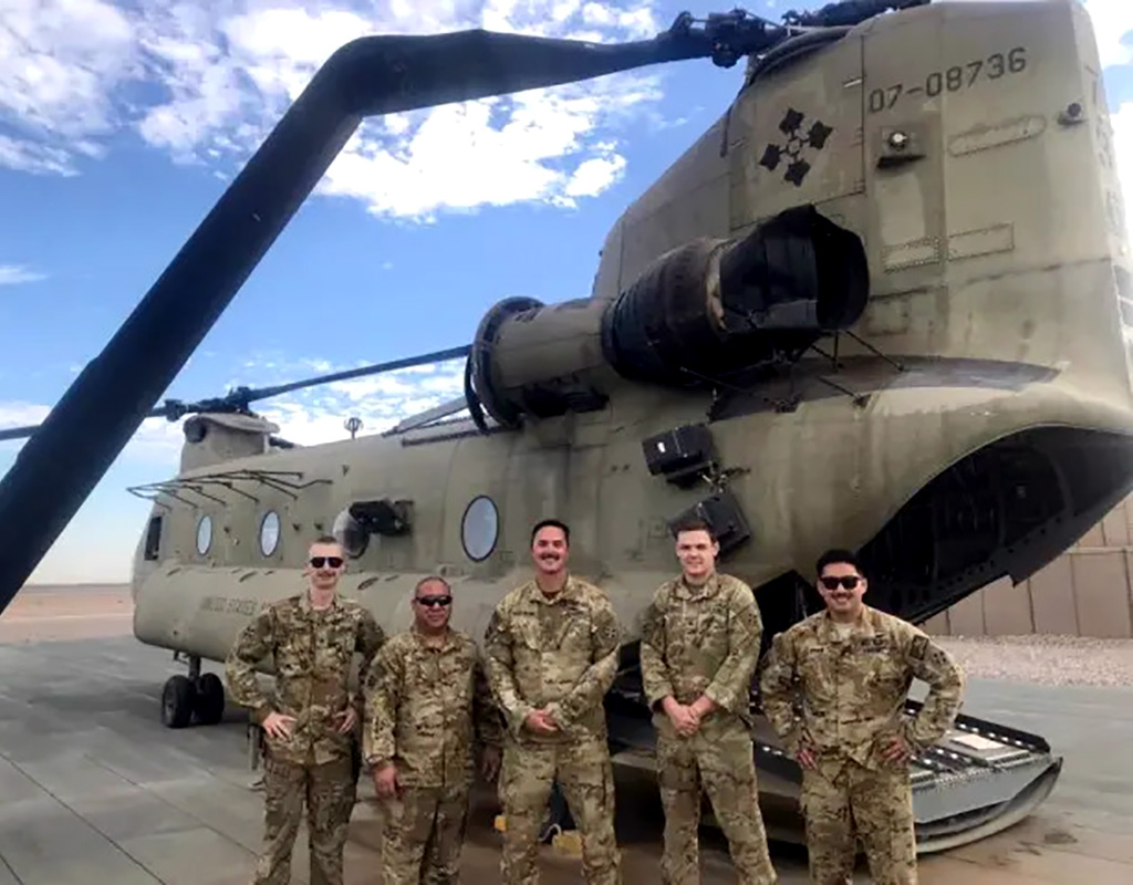 Five crew members pose in front of their damaged CH-47 Chinook helicopter. All five were awarded the U.S. Army Aviation Broken Wing Award for safely landing the damaged aircraft. U.S. Army Photo
