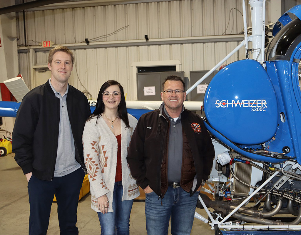 Schweizer North America Helicopter sales manager Robert Grimmett, Helicopter Institute director of administration Ashley Mikel, and Helicopter Institute president Randy Rowles with a refurbished Schweizer 300C that was delivered to Helicopter Institute. Schweizer Photo
