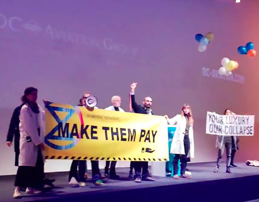 Extinction Rebellion activists protesting on the stage at AIROPS 2023 in Brussels. (credit: Extinction Rebellion Twitter)