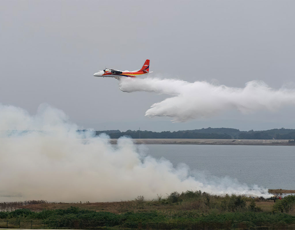 The MA60 firefighting aircraft conducts the water drop over a simulated fire scene during an emergency rescue drill at the Zhanghe Airport in Jingmen, central China's Hubei Province, Oct. 27, 2023. (AVIC).