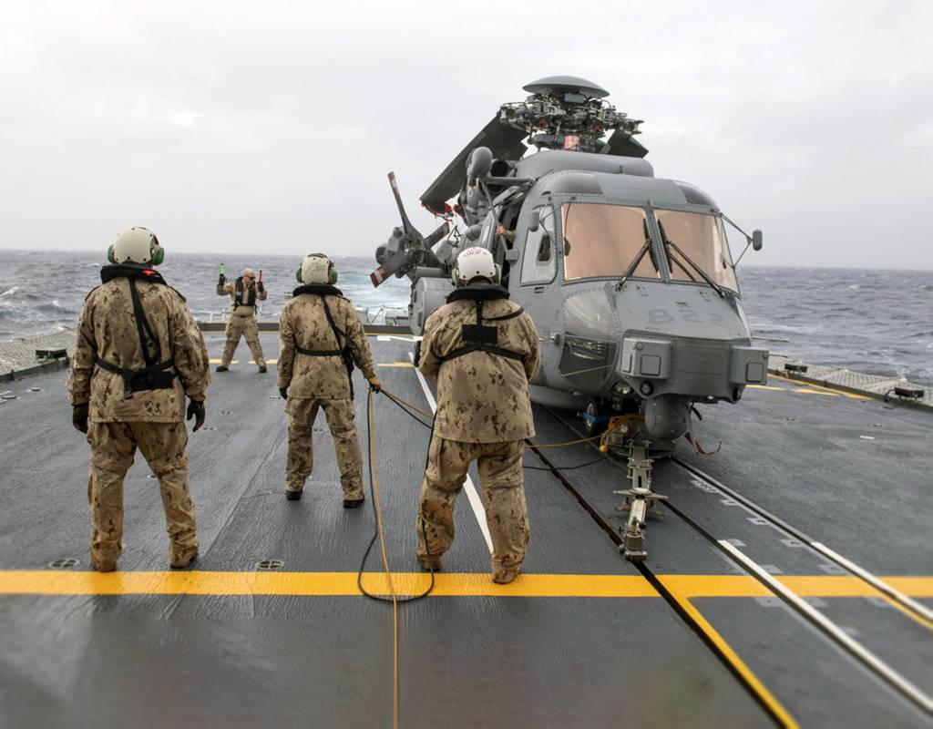 Crew members guide a CH-148 Cyclone helicopter into position aboard HMCS Fredericton during Operation Reassurance. Cpl Simon Arcand/RCAF Photo