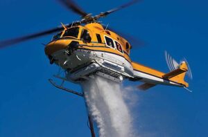 A Bell 412 operated by Wisk Air Helicopters demonstrates a water drop with its 375-US gallon (1,420 liter) Simplex Belly Tank. Like any helicopter customized for a specific mission, it carries a host of modifications that each require a supplemental type certificate (STC). Mike Reyno Photo