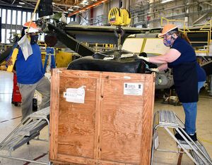 Coboros Davis, left, airframe mechanic, and D.J. Bowman, aircraft worker, use the V-22 sponson bladder sling to lift an Osprey’s sponson fuel bladder from a crate on Fleet Readiness Center East’s V-22 Osprey aircraft line. FRCE worked with a vendor to develop the new sling, also called a “dog bone,” which helps artisans lift and move the fuel bladders more safely and efficiently. NAVAIR Photo