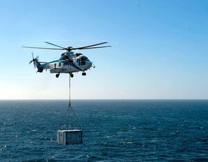 A civilian H225 Super Puma operated by Air Center Helicopters transports a mock F135 engine power module from Lewis and Clark-class dry cargo ship USNS Richard E. Byrd (T-AKE 4) to Nimitz-class nuclear aircraft carrier USS Carl Vinson (CVN 70) during a vertical replenishment-at-sea (VERTREP). U.S. Navy Photo by Mass Communication Specialist Seaman Mason Congleton