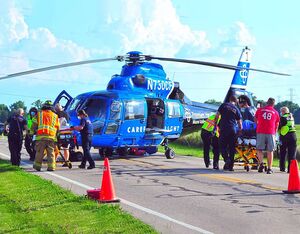 Firefighters and medics prepare to load a pair of patients aboard CareFlight following an August 2020 crash in Miami County. Mike Ulery Photo
