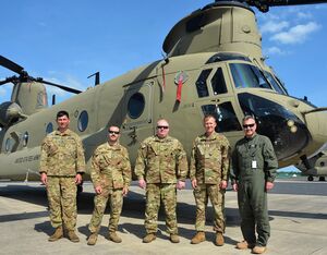(Left to right) Staff Sgt. Kyle Waller of the Illinois National Guard’s Company B, 238th General Support Aviation Battalion; Staff Sgt. Anthony Bearoff of the Pennsylvania National Guard’s Company B, 2-104th General Support Aviation Battalion; Staff Sgt. Robert Prigel, an instructor at the Eastern Army National Guard Aviation Site; Chief Warrant Officer 4 Kyle Kephart, an instructor pilots at EAATS; and Ron Henry, also an instructor pilot at EAATS, pose in front of a CH-47 Chinook helicopter on Muir Army Airfield at Fort Indiantown Gap, Pa., on May 25, 2022. Brad Rhen for Pennsylvania National Guard Photo