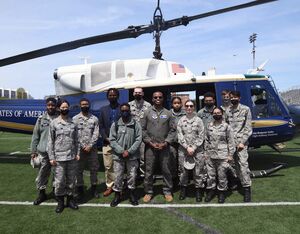 Members from the Civil Air Patrol pose for a photo with 1st Lt. Dontae Bell, 1st Helicopter Squadron pilot, (center) at Greene Stadium, Washington D.C., April 30, 2022. The 1st HS hosted the “We Fly, Too” event to promote diversity in aviation. Senior Airman Spencer Slocum for U.S. Air Force Photo