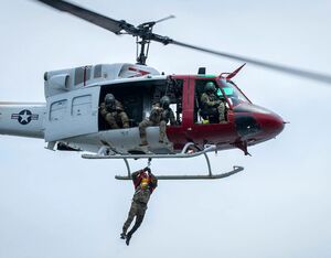 A Survival, Evasion, Resistance and Escape student from the 492nd Special Operations Wing reaches the 413th Flight Test Squadron UH-1 Huey during a test of the hoist system above the waters near Eglin Air Force Base, Florida Aug. 16. Samuel King Jr. for U.S. Air Force Photo