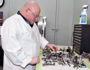 John Stilley pneudraulic systems mechanic leader in the Fleet Readiness Center East (FRCE) Fuel Control Shop, assembles a T64 engine’s fuel control unit in a clean room. FRCE Photo