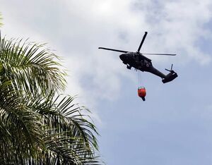 The National Guard helicopter carries a Bambi Bucket full of water to dump on the fire in Utuado, Puerto Rico, June 2023. (Carlos Edill Berríos Polanco/Latino Rebels)