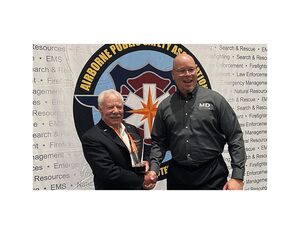 Mike Atwood, founder and CEO of Aviation Specialties Unlimited (ASU), stands with his Public Safety Award from the Airborne Public Safety Association.