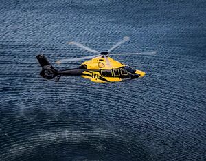 An Airbus H160 helicopter, operated by PHI, flies over rippling water. Airbus Helicopters Photo