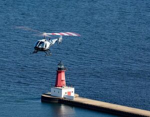 A 280FX flies over the Menominee North Pier lighthouse near the company's facility. Brent Bundy Photo
