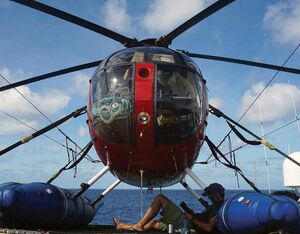 As a tuna boat helicopter pilot, there is plenty of time to sit back and relax. Here, the author rests under his MD 500 while reading a book. Matthew Hayes Photo