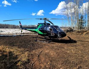 The Phoenix HeliFlight AS350 B2 piloted by Cameron Spring lands in the front yard of a remote cabin cut off by a rising Athabasca River. Cameron Spring Photo