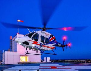 A Mercy Flight Bell 429 lands on a rooftop helipad at a hospital in Buffalo, New York. The windsock indicating wind direction and speed is illuminated on top of the building behind the aircraft. Mike Reyno Photo